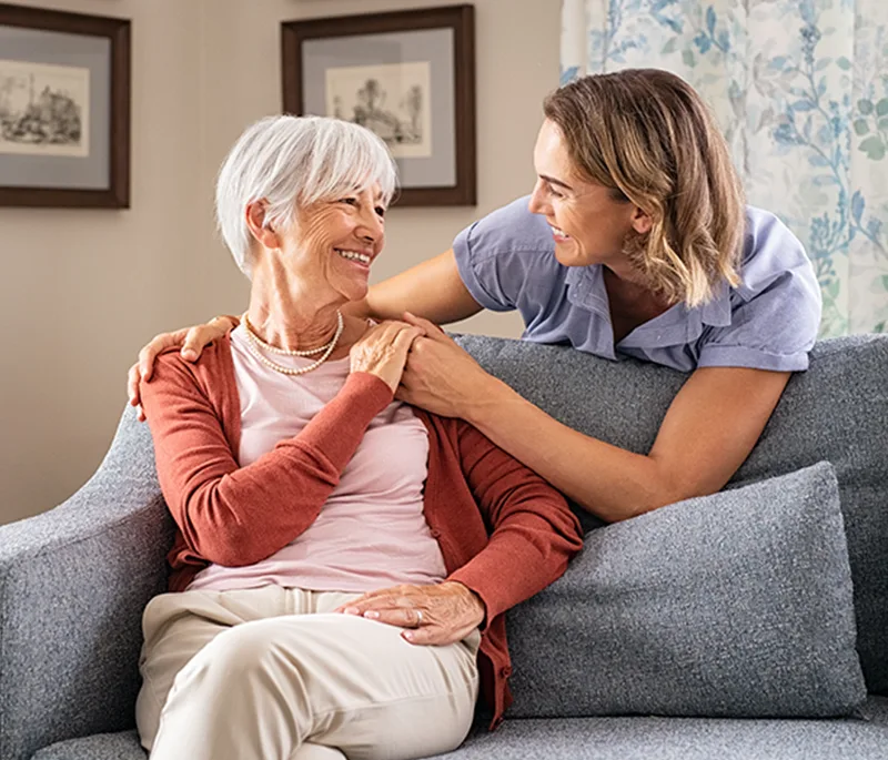 Une infirmière enlace une dame agée